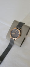 Cargar imagen en el visor de la galería, Reloj para mujer color gris grafito, con elegante pulsera de malla tejida en acero inoxidable, con cristal facetado. Case color rose gold, mediano 34mm.
