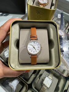 Reloj para mujer color rose gold, con correa de cuero color marrón y dial blanco madre perla